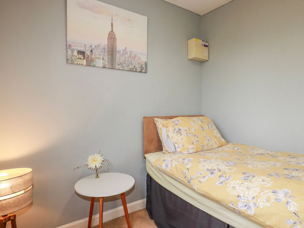 A bedroom with a bed and wall art at Likely Sunset in St. Austell