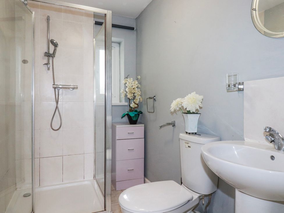 A bathroom with a shower, toilet, and sink at Likely Sunset in St. Austell