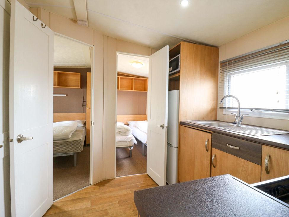 A kitchen with a sink and cupboards at Caravan 102 seawick Clacton-on-Sea