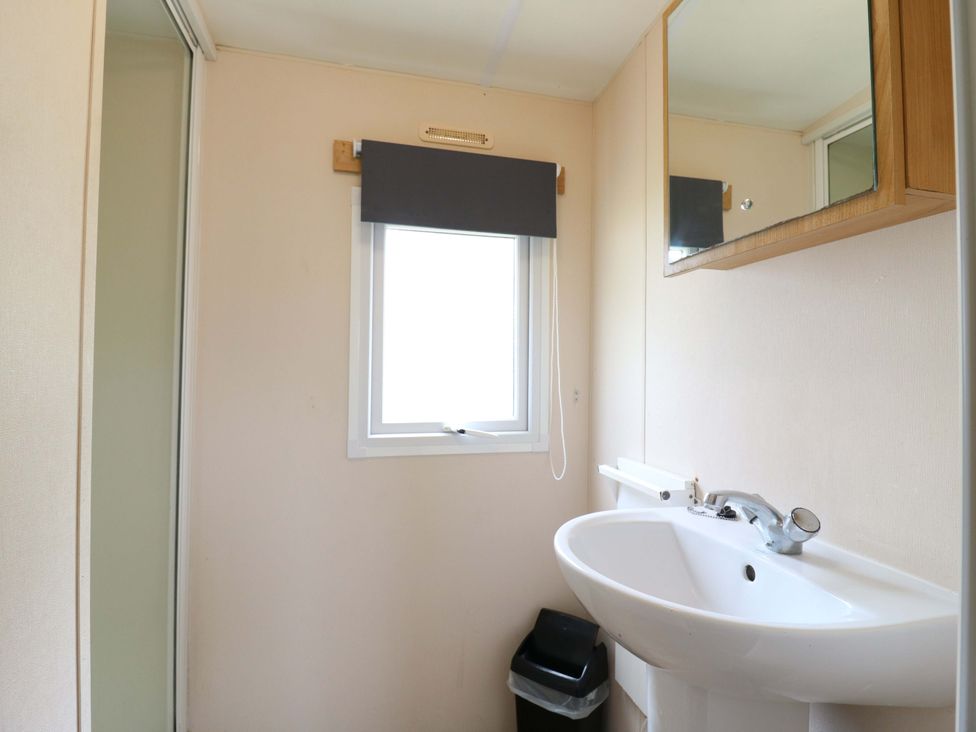 A bathroom with a sink and mirror at Caravan 102 seawick in Clacton-on-Sea