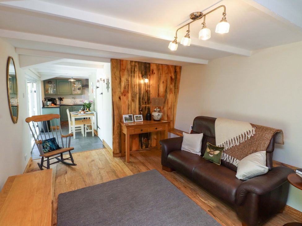 A living room with a sofa and rocking chair at Woodman's Lodge Llanallgo near Moelfre