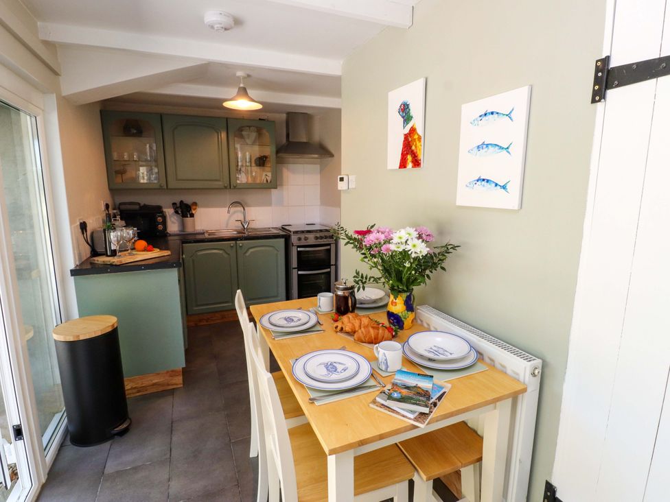 A kitchen with a table set for breakfast at Woodman's Lodge in Llanallgo near Moelfre