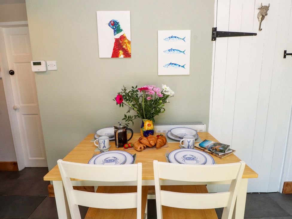 A dining room with a table set for breakfast at Woodman's Lodge Llanallgo near Moelfre