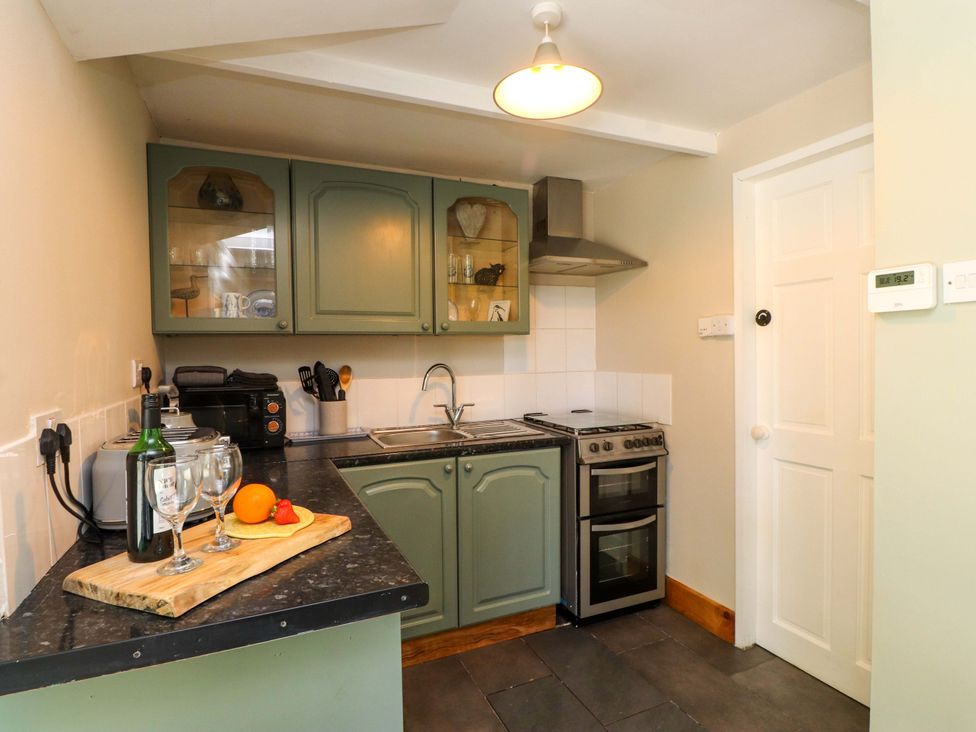 A kitchen with appliances and utensils at Woodman's Lodge in Llanallgo near Moelfre