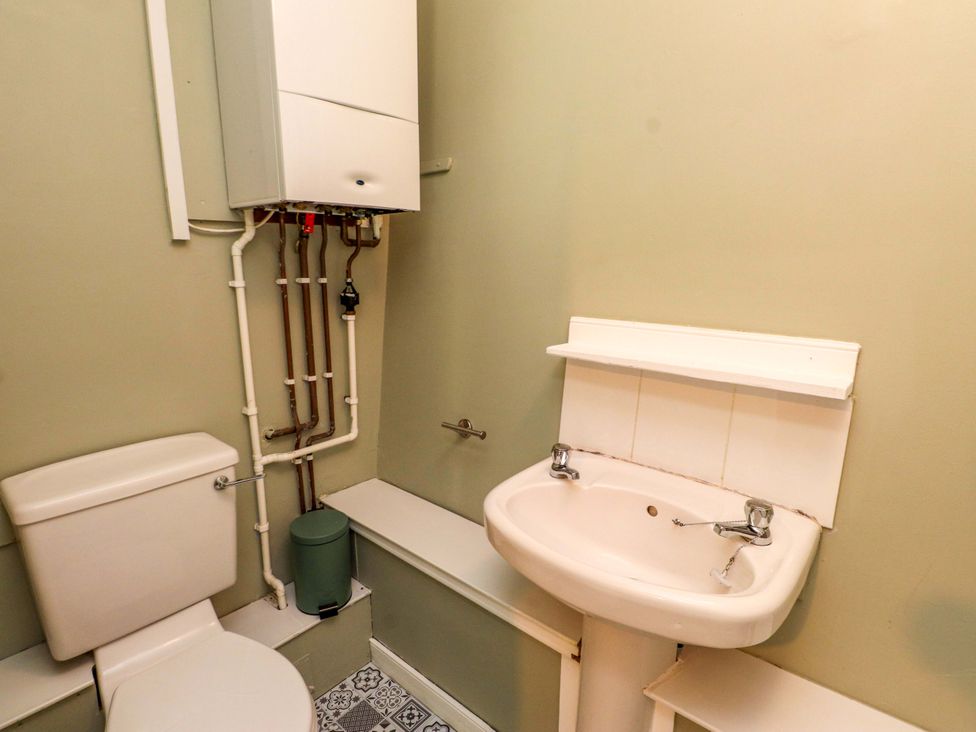 A bathroom with a toilet and sink at Woodman's Lodge in Llanallgo near Moelfre
