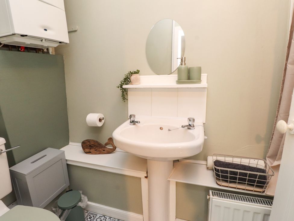 A bathroom with a sink and toilet at Woodman's Lodge Llanallgo near Moelfre