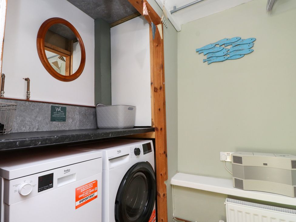 A laundry room with washing machine and tumble dryer at Woodman's Lodge in Llanallgo near Moelfre