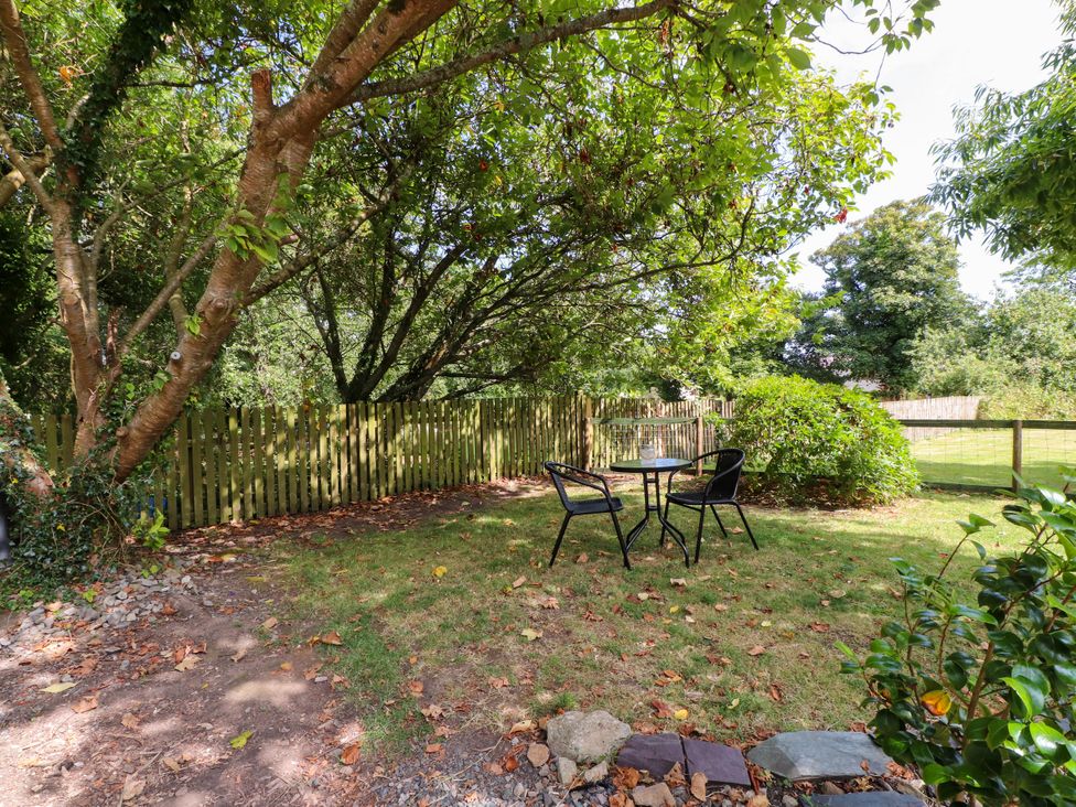 A garden area with a table and chairs at Woodman's Lodge Llanallgo near Moelfre