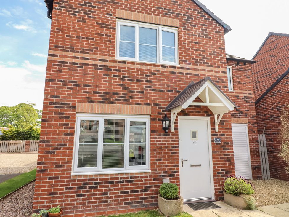 An exterior view of a house with brick walls and a door at 26 Field Court 