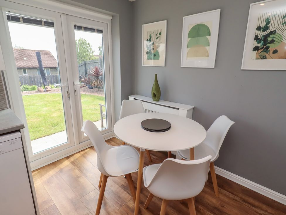A dining room with a round table and chairs at 26 Field Court