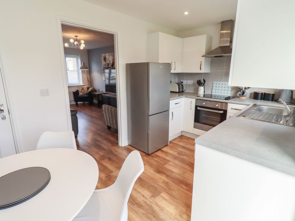 A kitchen with appliances and a dining area at 26 Field Court