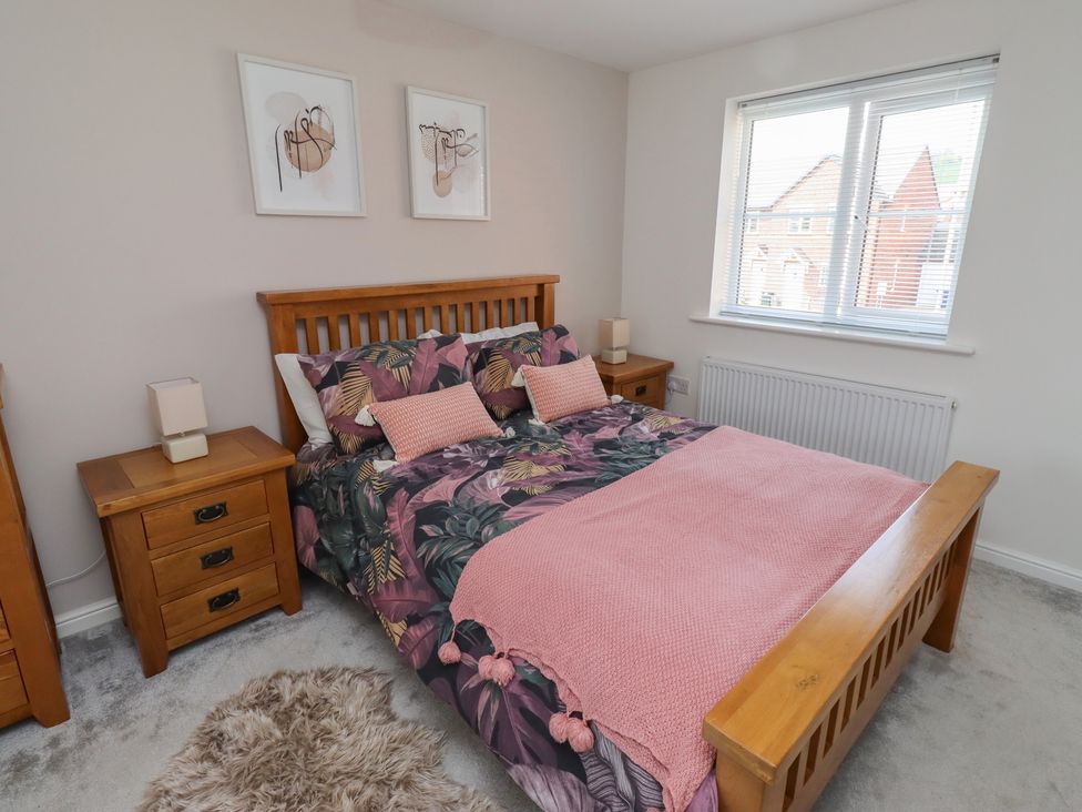 A bedroom with a bed and bedside tables at 26 Field Court
