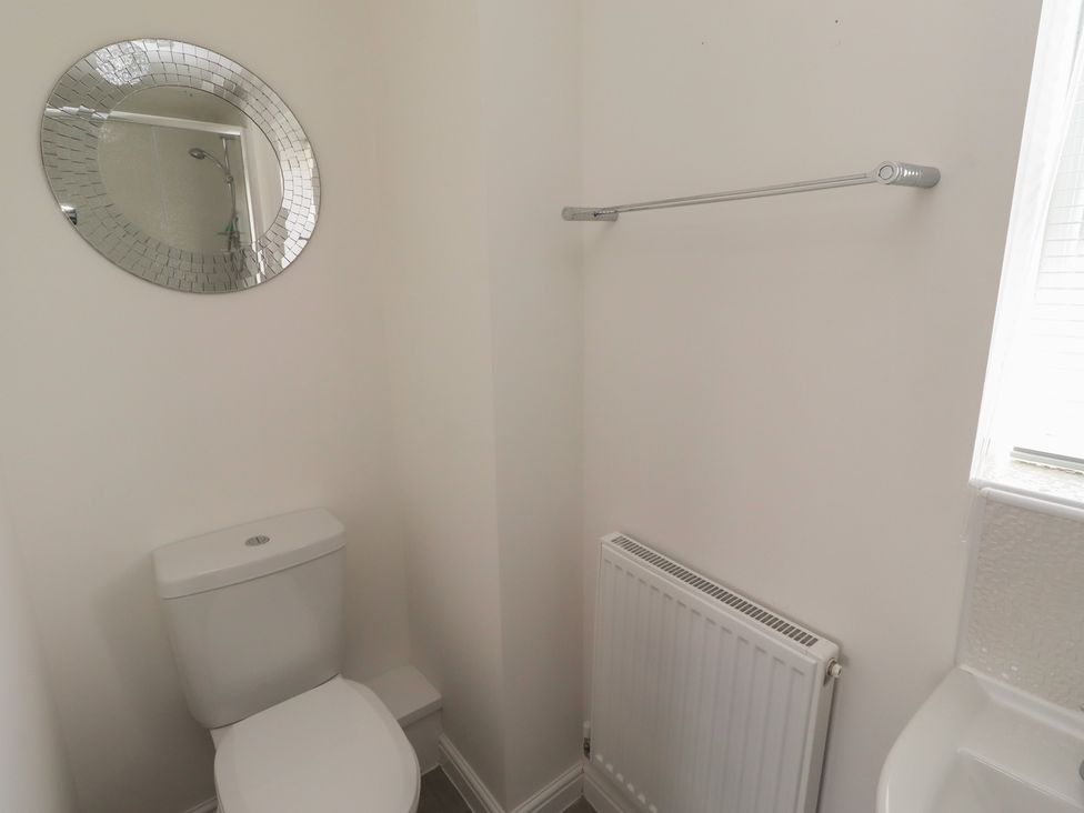 A bathroom with a toilet and a mirror at 26 Field Court
