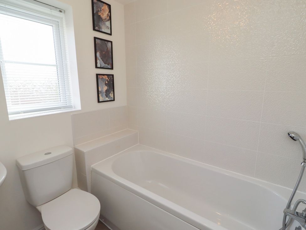 A bathroom with a bathtub and toilet at 26 Field Court