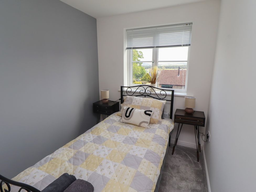 A bedroom with a bed and bedside tables at 26 Field Court