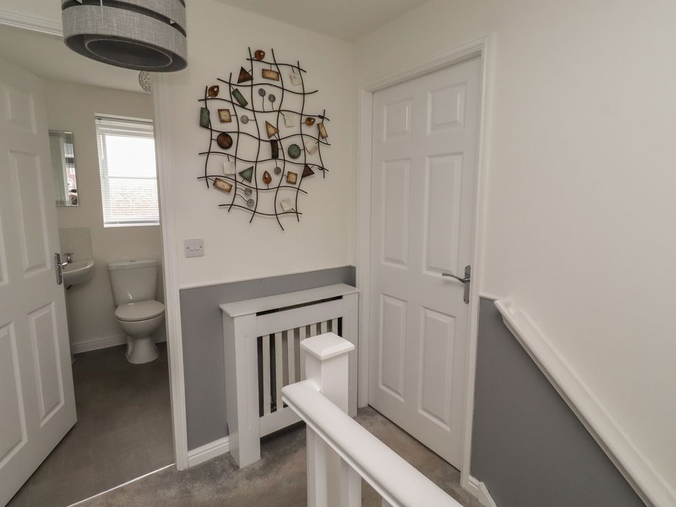 A hallway with a staircase and a toilet at 26 Field Court 