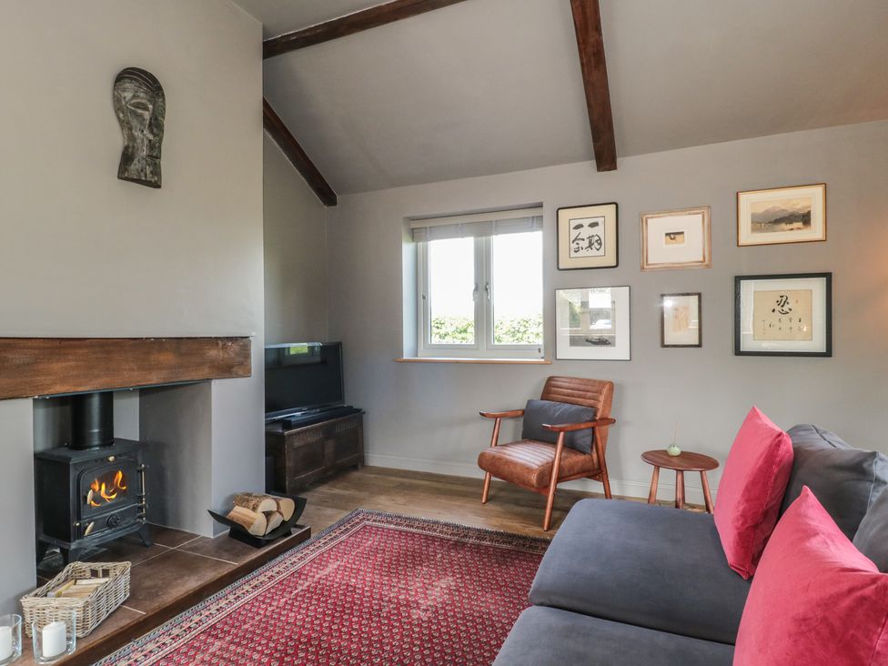 A living room with a fireplace and chair at Annex at Barnfield House Devizes