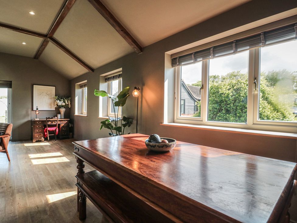 A dining area with a wooden table and chairs at Annex at Barnfield House Devizes
