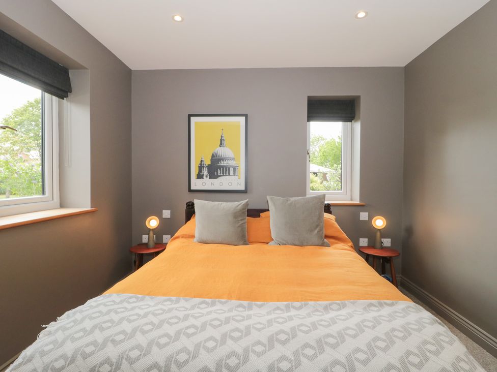 A bedroom with a bed and windows at Annex at Barnfield House in Devizes