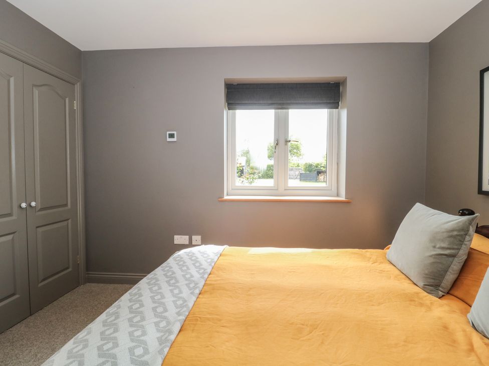 A bedroom with a bed and window at Annex at Barnfield House in Devizes