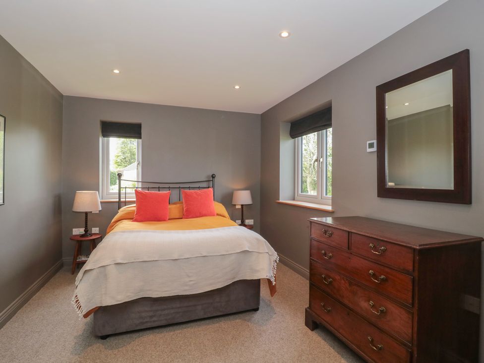 A bedroom with a bed and a dresser at Annex at Barnfield House in Devizes