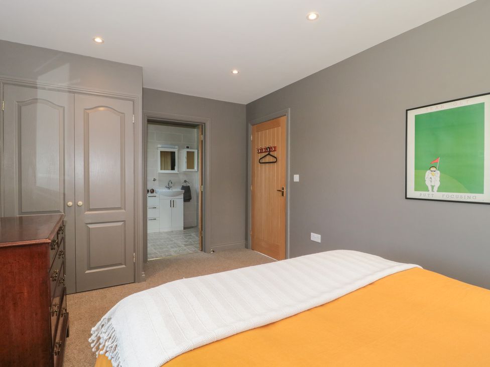 A bedroom with a bed and chest of drawers leading to a bathroom at Annex at Barnfield House Devizes
