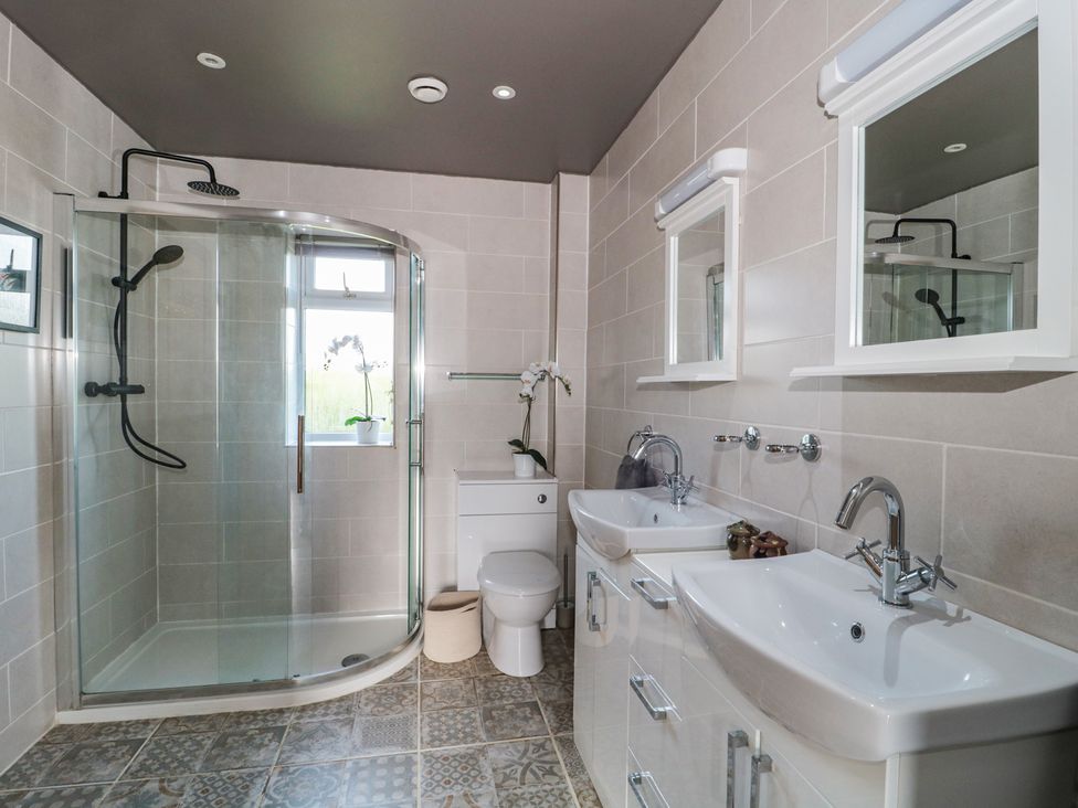 A bathroom with a shower toilet and sinks at Annex at Barnfield House Devizes