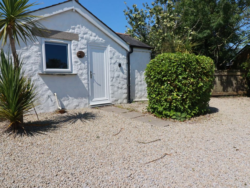 A house with a door and window surrounded by gravel and plants at Primrose Cottage Redruth
