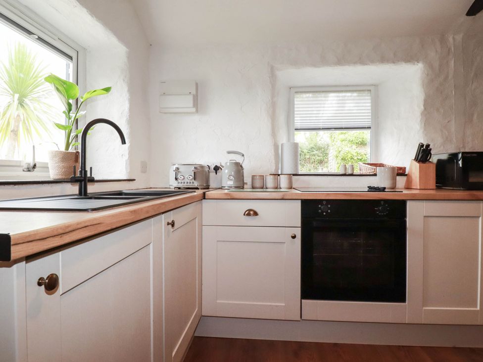 A kitchen with a sink and appliances at Primrose Cottage in Redruth