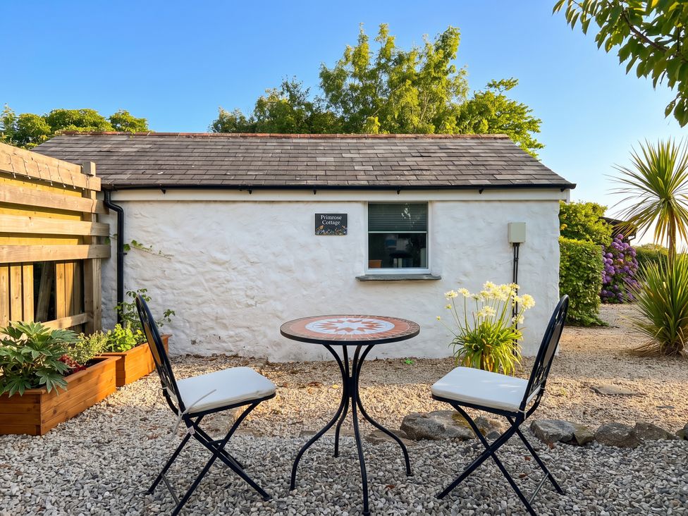 A table and chairs in an outdoor area at Primrose Cottage in Redruth
