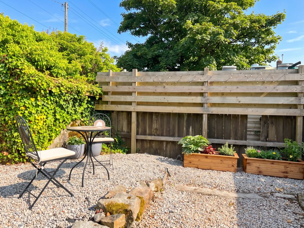 A garden with a table and chair at Primrose Cottage in Redruth