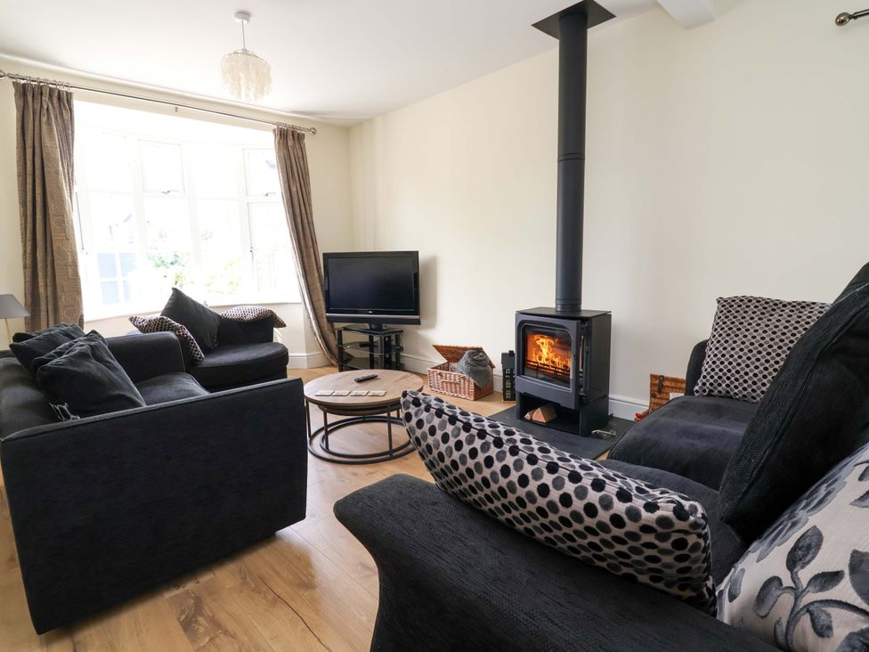 A living room with a sofa, coffee table and television at 18 Crewe Road in Crewe