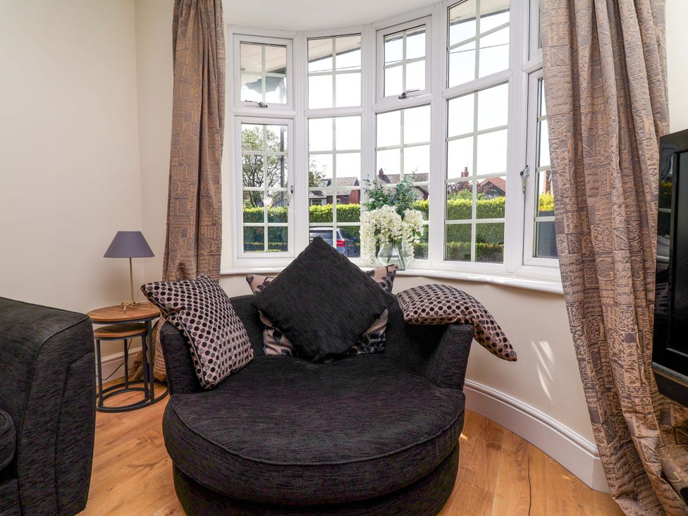 A living room with an armchair and side table at 18 Crewe Road, Crewe