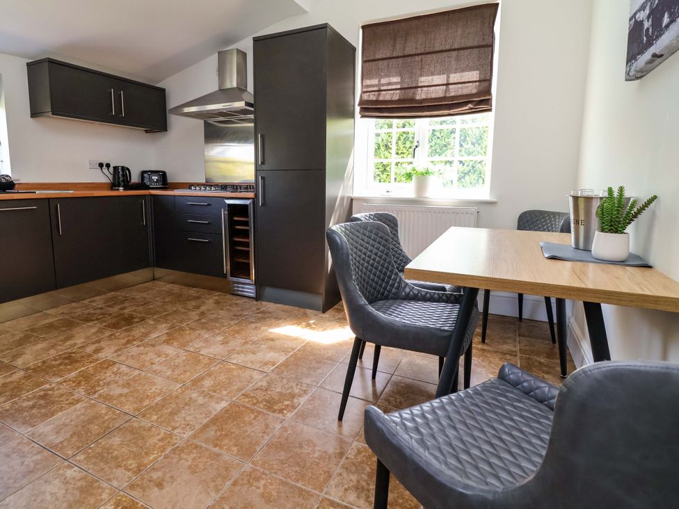 A kitchen with cabinets, stove and table at 18 Crewe Road in Crewe