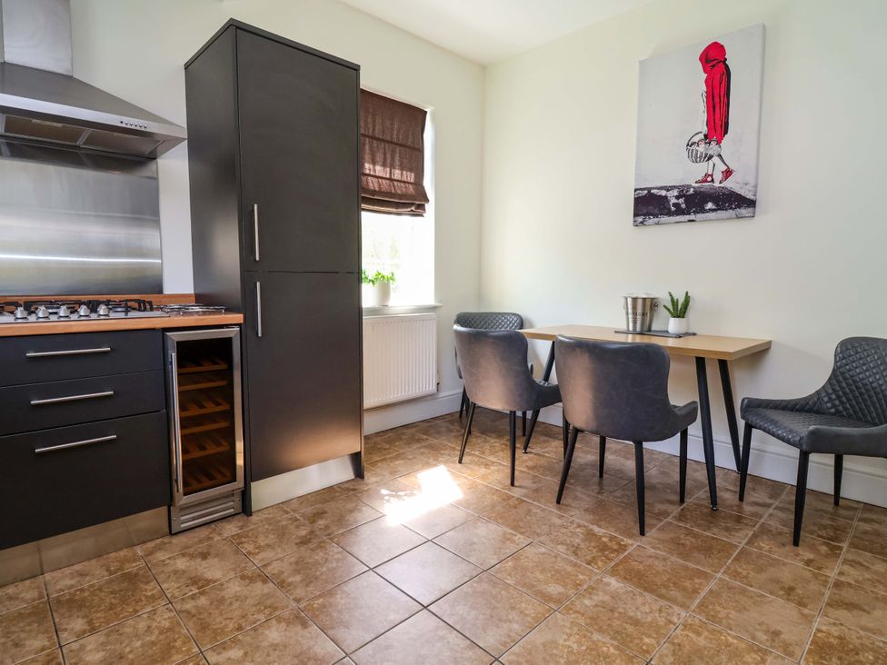 A kitchen with a gas stove and dining table at 18 Crewe Road Crewe