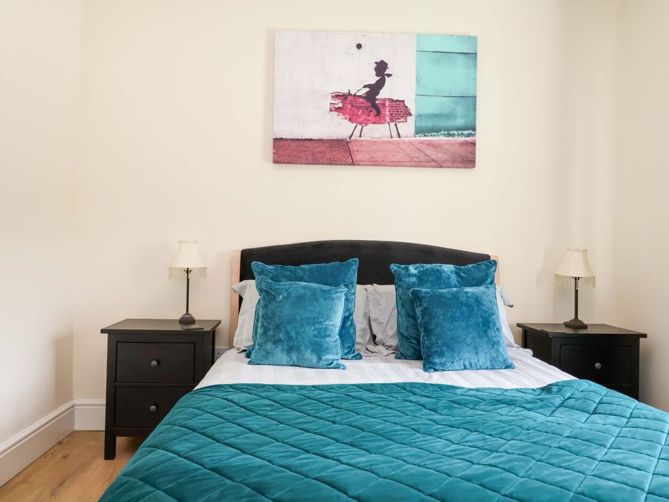 A bedroom with a bed and nightstands at 18 Crewe Road, Crewe