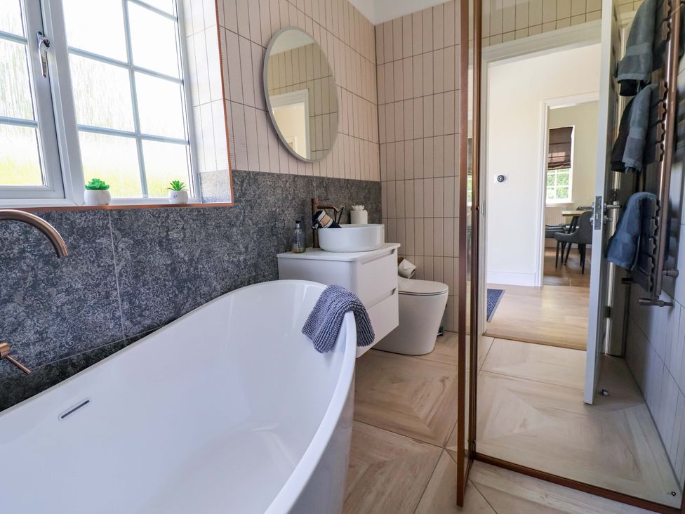 A bathroom with a bathtub, sink, and toilet at 18 Crewe Road in Crewe