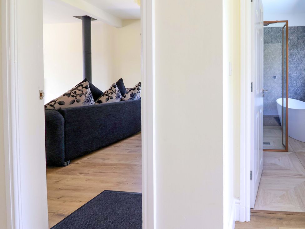A living room with a sofa and a view of a bathroom at 18 Crewe Road, Crewe