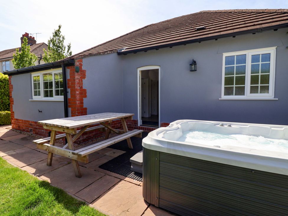 An outdoor area with a picnic table and hot tub at 18 Crewe Road, Crewe