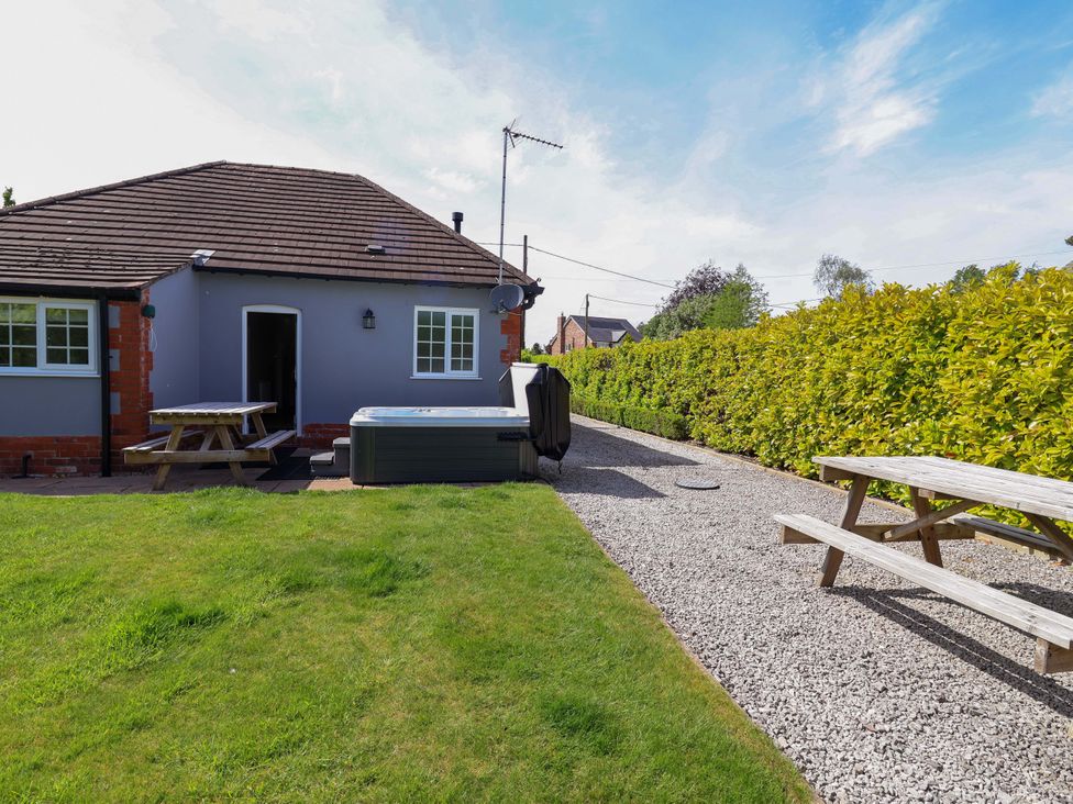 A garden with a hot tub and picnic table at 18 Crewe Road Crewe