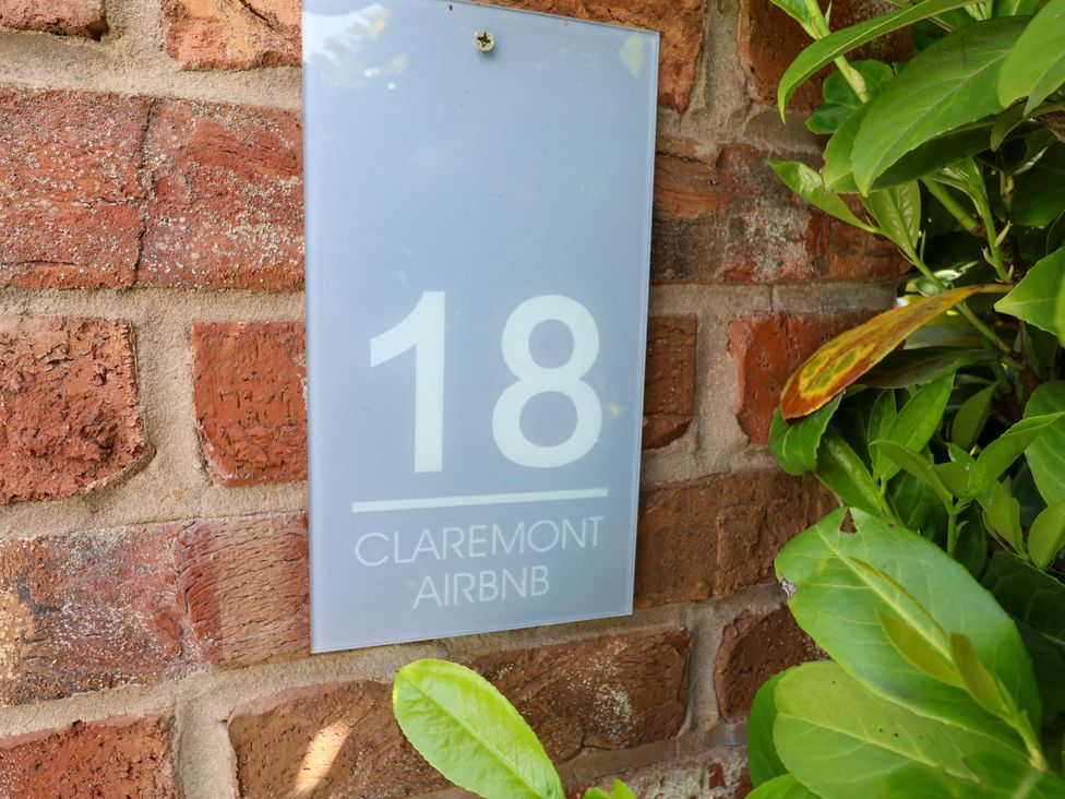 A house number sign on a brick wall at 18 Claremont Airbnb in Crewe