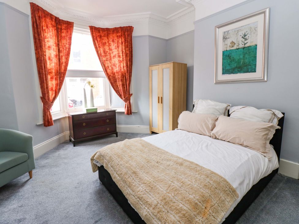 A bedroom with a bed and curtains at 17 Fairfield Road