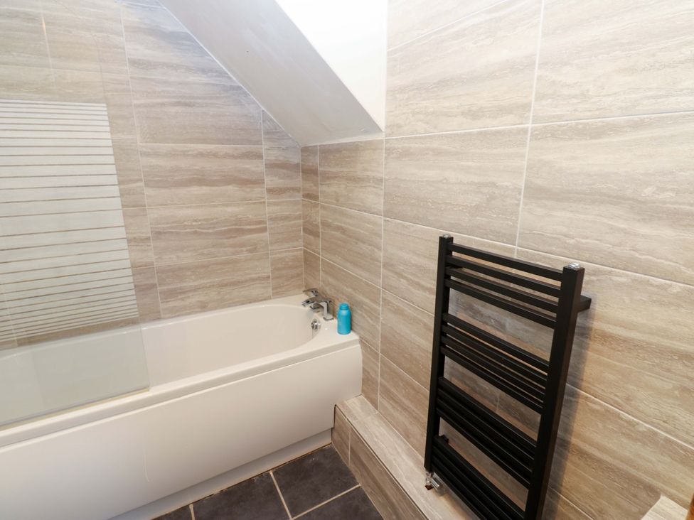 A bathroom with a bathtub and towel warmer at 17 Fairfield Road