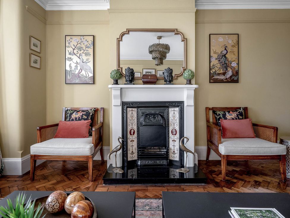 A living room with a fireplace and armchairs at Greenwood Manor in Peterborough