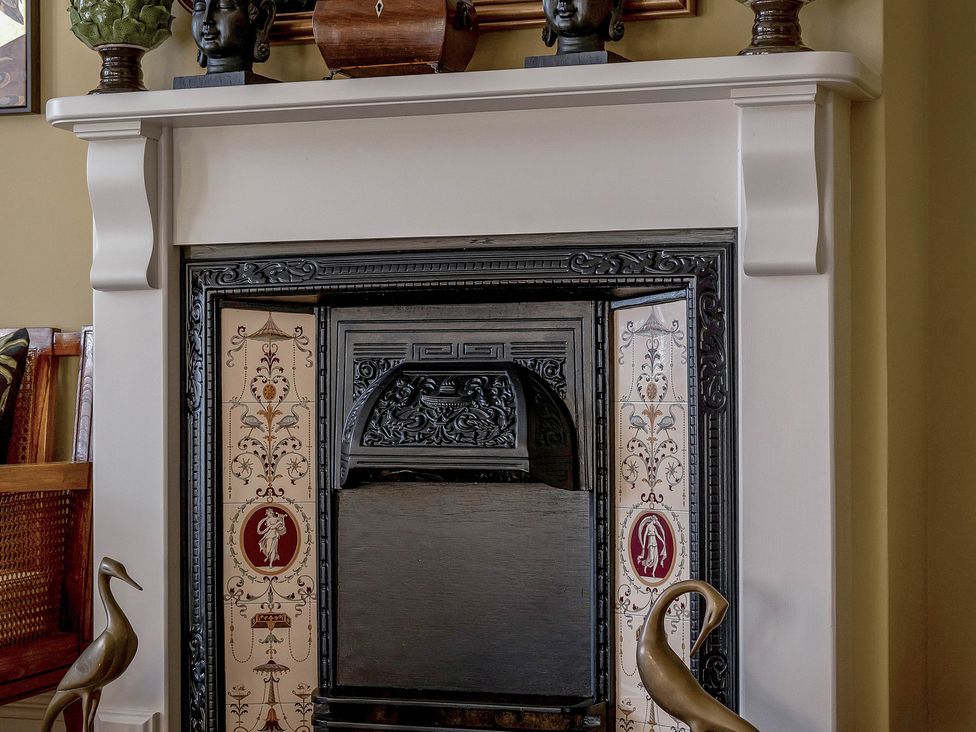 A fireplace with decorative tiles and busts at Greenwood Manor in Peterborough
