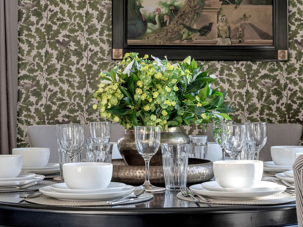 A dining table set with bowls, plates, glasses, and a flower arrangement at Greenwood Manor in Peterborough