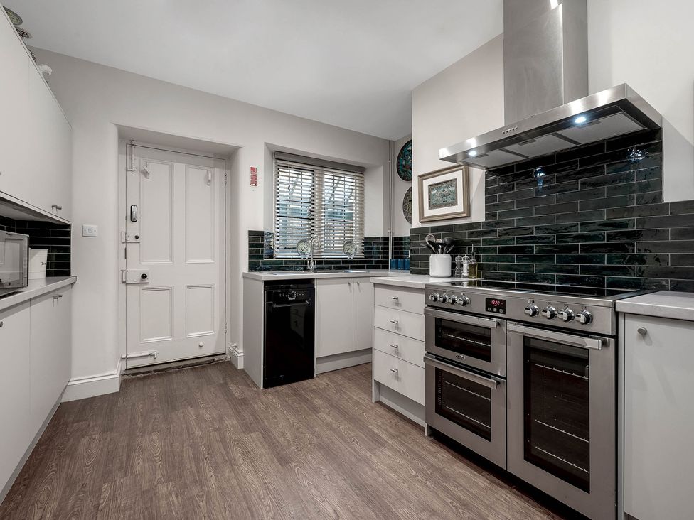 A kitchen with appliances and a door at Greenwood Manor in Peterborough