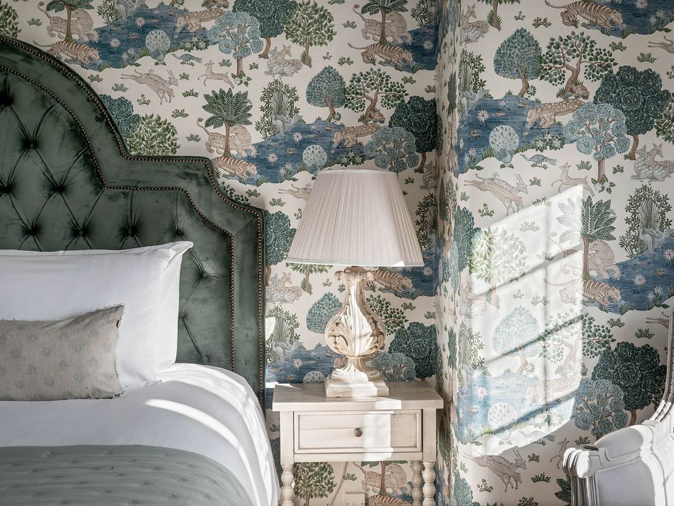 A bedroom with a bed, lamp, and nightstand at Greenwood Manor in Peterborough