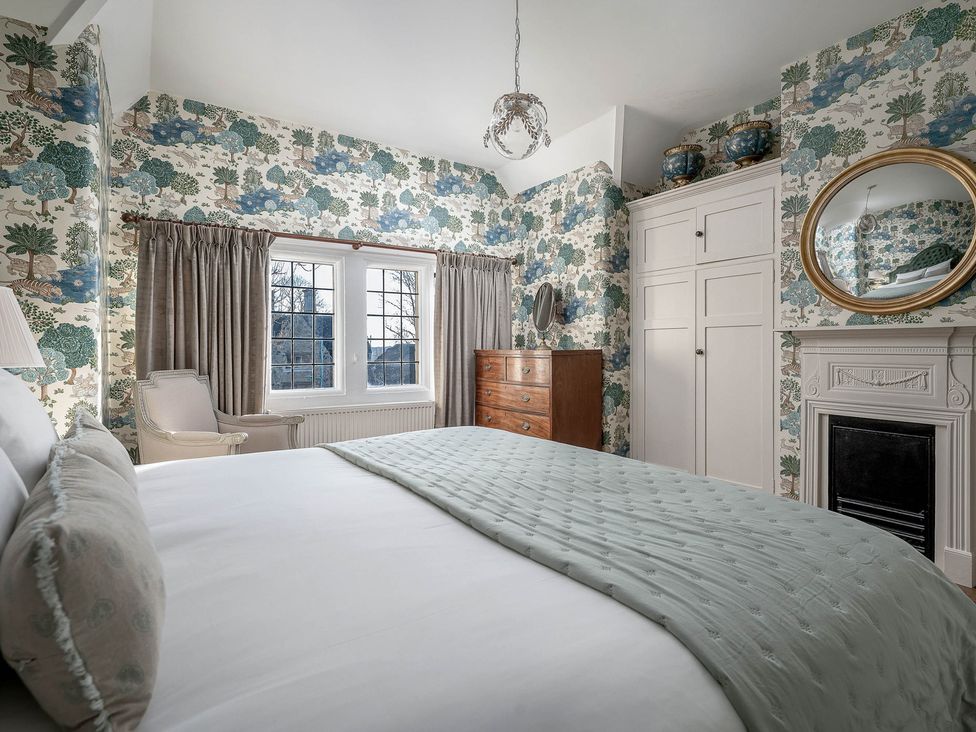 A bedroom with a bed and chest of drawers at Greenwood Manor in Peterborough