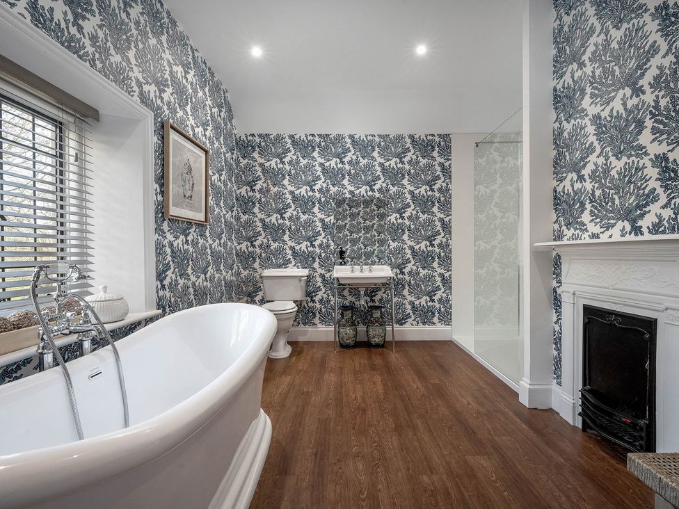 A bathroom with a bathtub, sink, and toilet at Greenwood Manor in Peterborough